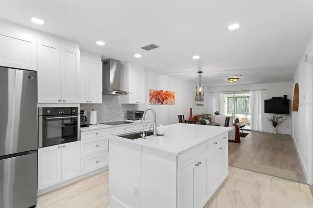 a kitchen that has a lot of cabinets a sink and appliances