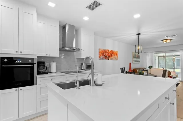 a kitchen with stainless steel appliances granite countertop a sink a stove and a refrigerator