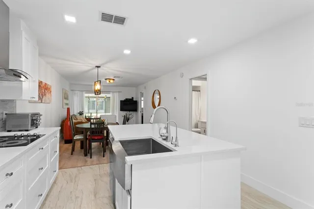 a kitchen with a sink a stove and chairs