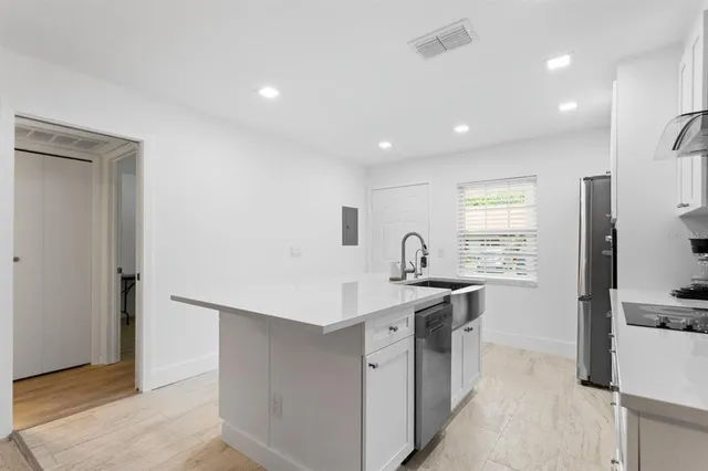 a kitchen with stainless steel appliances granite countertop a sink and a stove
