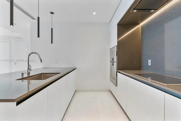 a kitchen with stainless steel appliances a refrigerator sink and white cabinets