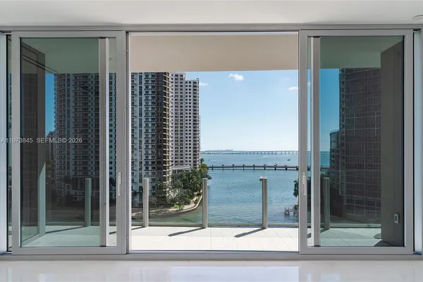 a view of a bathroom with a glass door shower and window