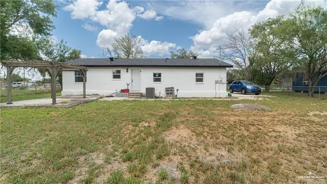 a view of a house with a big yard and a large tree