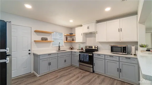 a kitchen with white cabinets stainless steel appliances and sink
