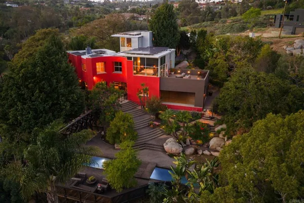 an aerial view of a house with a yard and a large tree