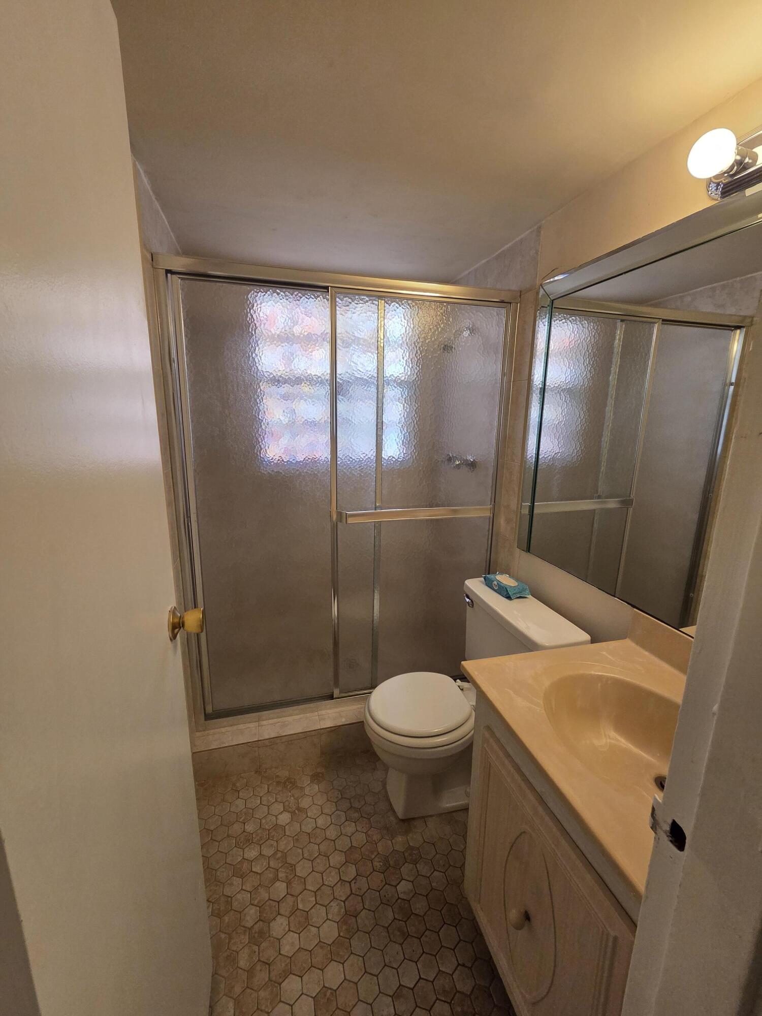 14790 Bonaire Boulevard, Unit 104 Delray Beach, FL 33446 - Photo 11 of 12 a bathroom with a sink toilet and shower