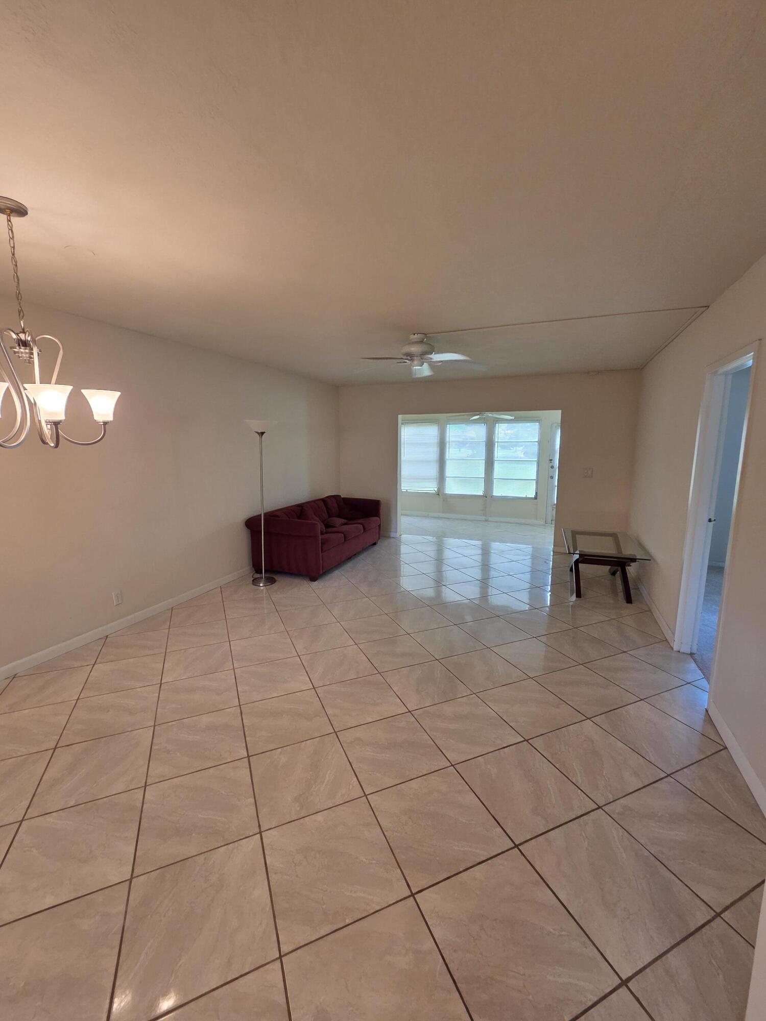 14790 Bonaire Boulevard, Unit 104 Delray Beach, FL 33446 - Photo 4 of 12 a view of empty room with wooden floor and fan