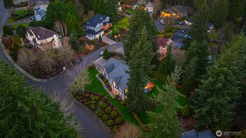 an aerial view of residential house with outdoor space and trees all around