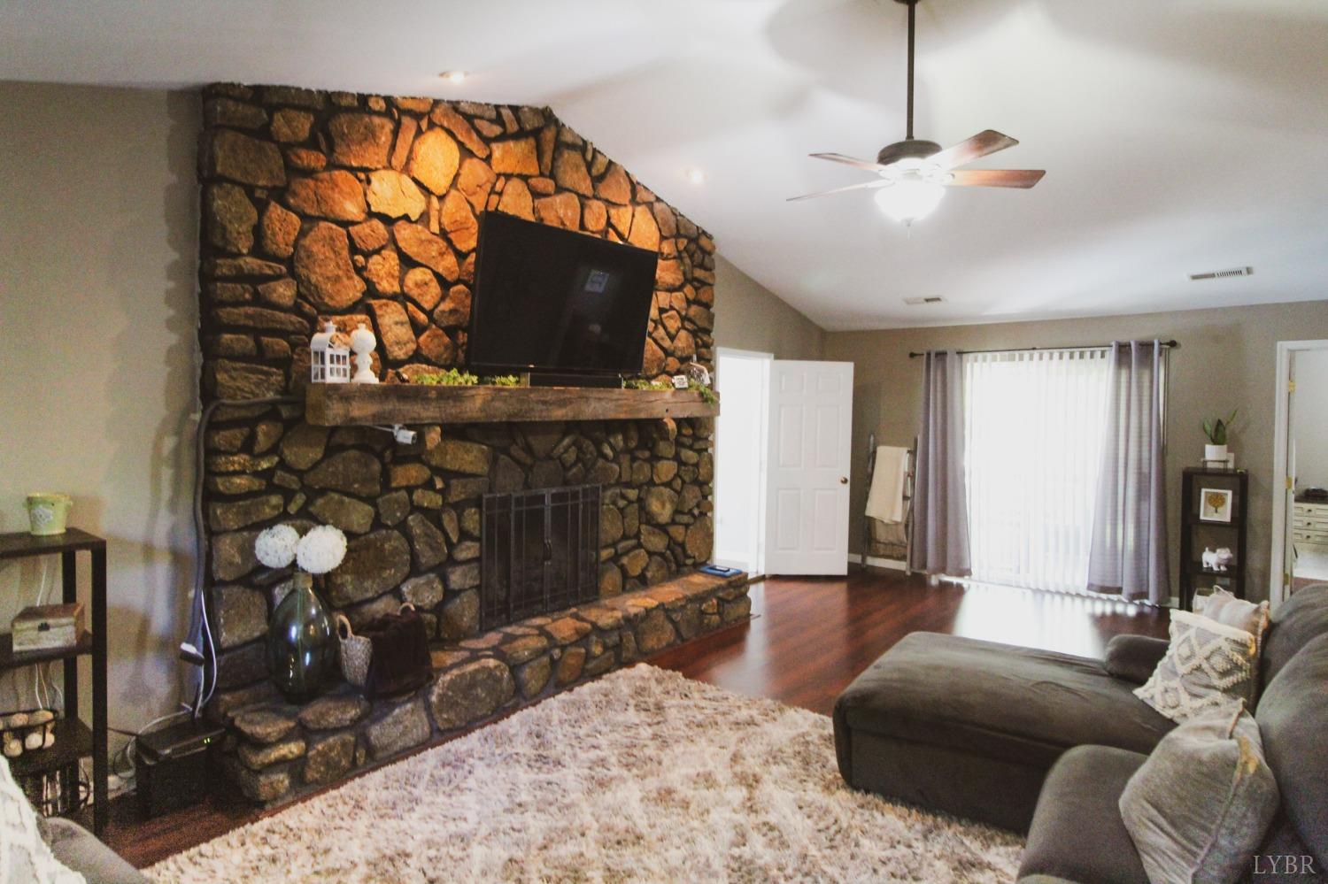1217 Wood Road Lynchburg, VA 24502 - Photo 12 of 29 a living room with furniture a flat screen tv and a fireplace