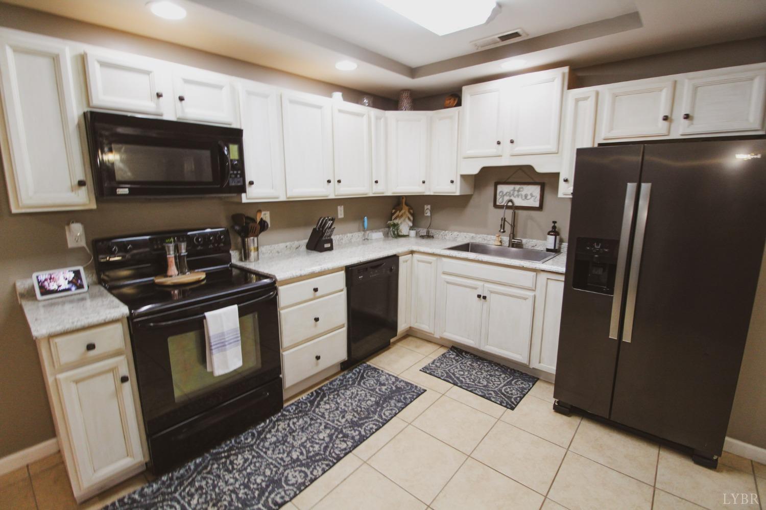 1217 Wood Road Lynchburg, VA 24502 - Photo 7 of 29 a kitchen with a sink stove and white cabinets