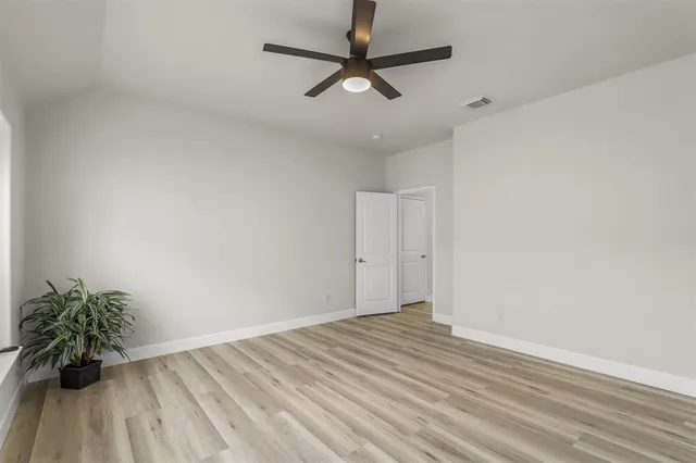 a view of a room with wooden floor and a ceiling fan