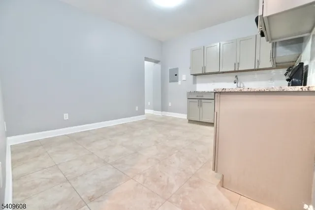 a view of kitchen with granite countertop cabinets and sink