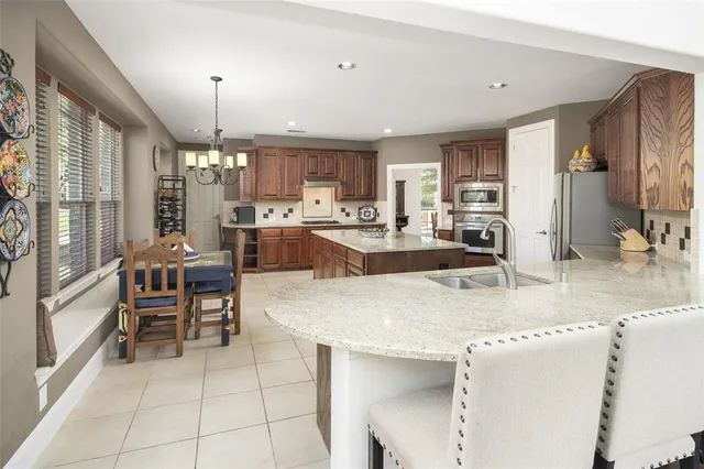 a large kitchen with kitchen island granite countertop a large counter top stainless steel appliances and cabinets
