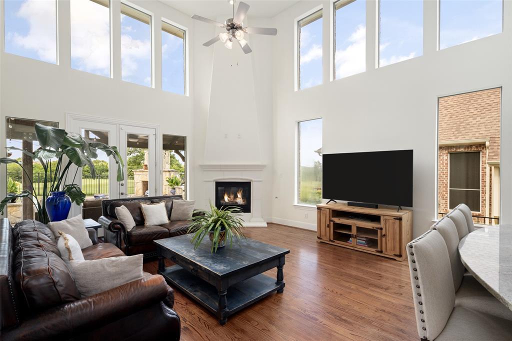 2801 Meadow Ridge Drive Prosper, TX 75078 - Photo 18 of 40 a living room with furniture a flat screen tv and a fireplace