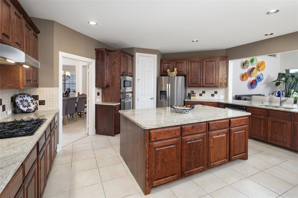 2801 Meadow Ridge Drive Prosper, TX 75078 - Photo 10 of 40 a kitchen with stainless steel appliances granite countertop a stove refrigerator and cabinets