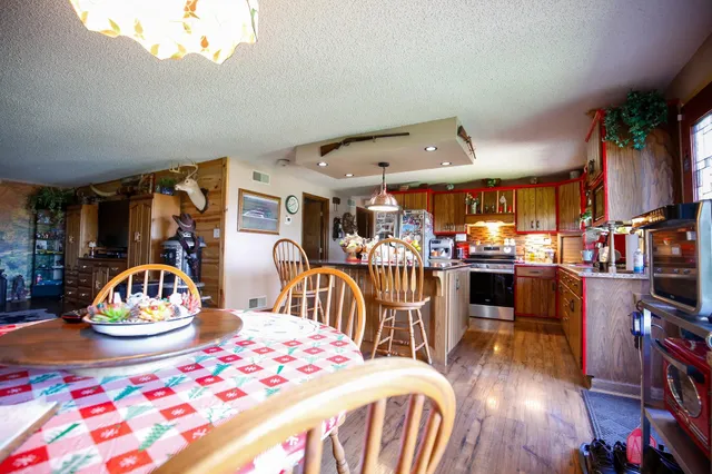 a kitchen with stainless steel appliances granite countertop a refrigerator a sink dishwasher a stove with wooden floor and cabinets