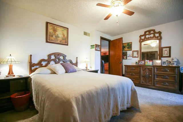 a bedroom with a bed dresser and a large window