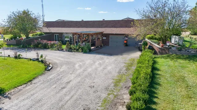 a view of a house with a yard and potted plants