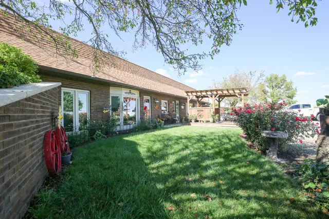 a view of a house with a big yard and large trees