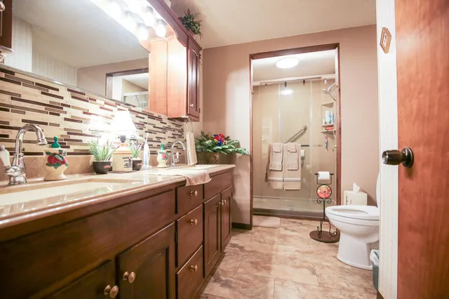 a spacious bathroom with a sink a toilet a tub and shower