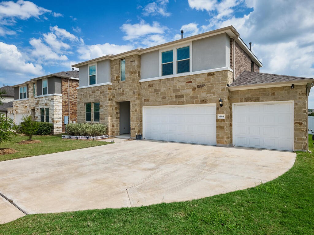 a front view of a house with a yard and garage