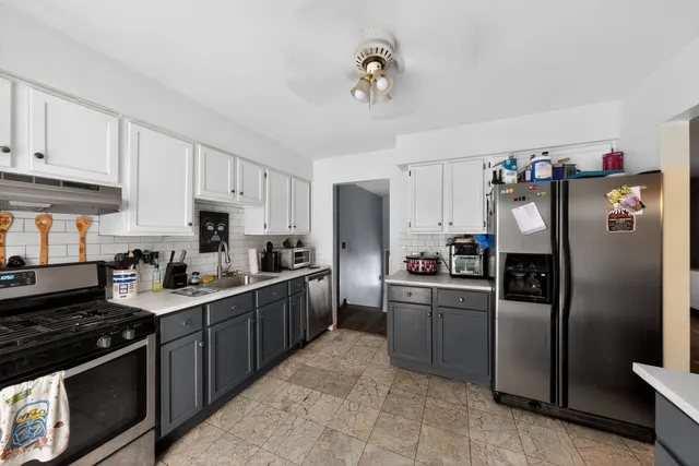 a kitchen with stainless steel appliances granite countertop a refrigerator stove and sink