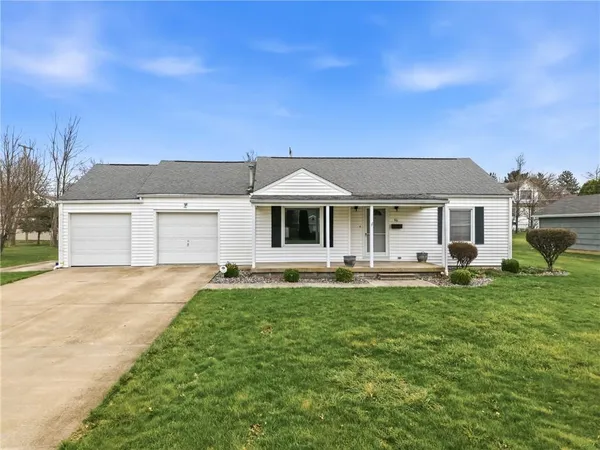 a front view of a house with a garden and yard