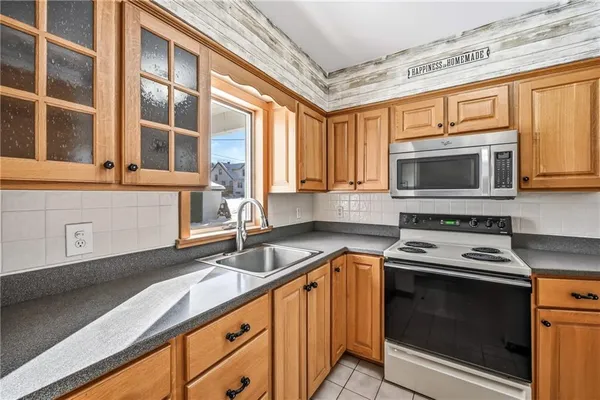 a kitchen with stainless steel appliances granite countertop a stove a sink and a microwave