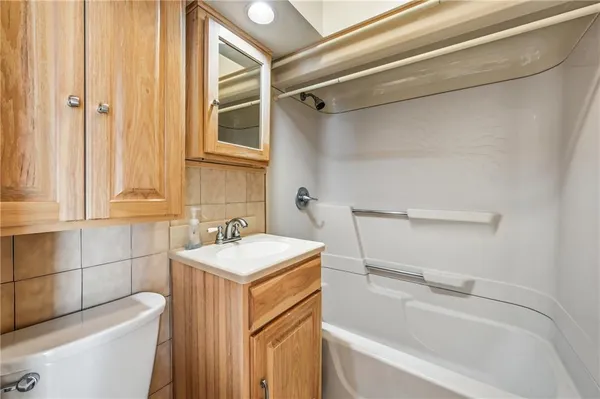a bathroom with a sink toilet vanity and tub