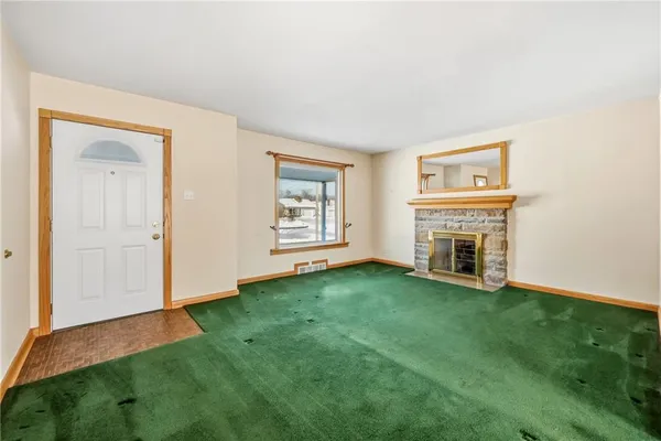 an empty room with windows and fireplace