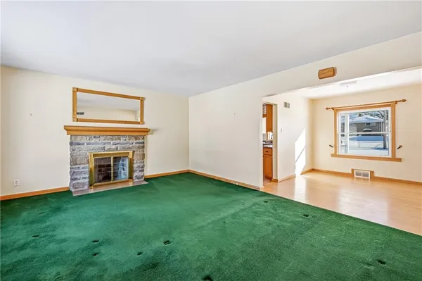 a view of an empty room with window and fire place