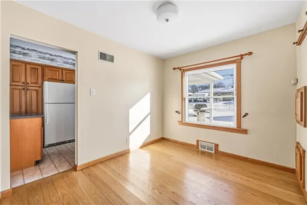 an empty room with wooden floor and a window