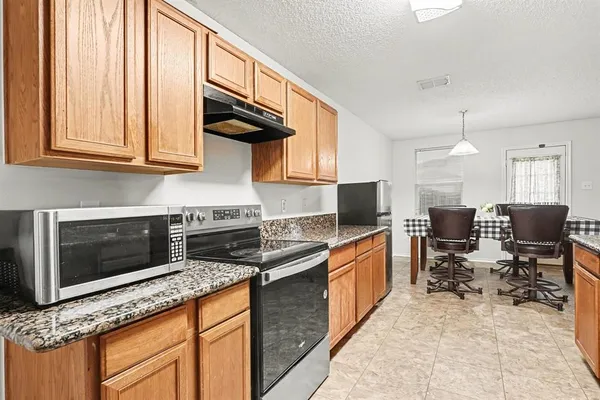 a kitchen with stainless steel appliances granite countertop a stove a sink and a microwave