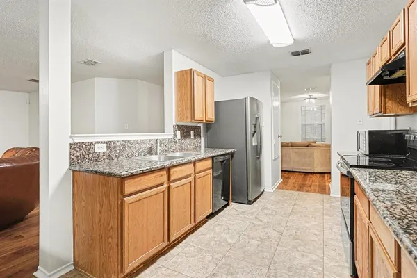 a kitchen with stainless steel appliances granite countertop a refrigerator and a sink