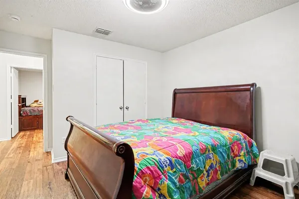 a bedroom with a bed and wooden floor