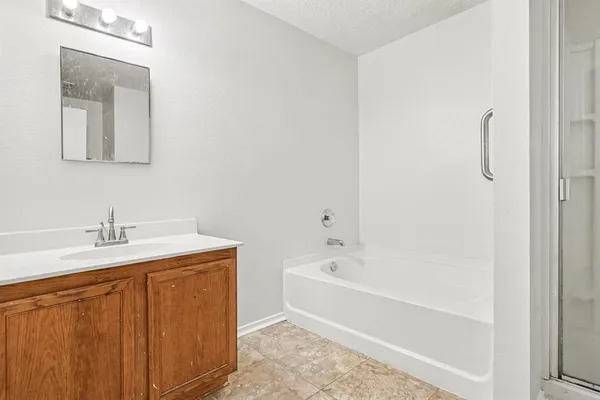 a bathroom with a granite countertop sink toilet and bathtub