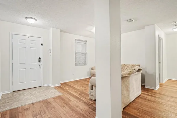 a view of a hallway with wooden floor and closet