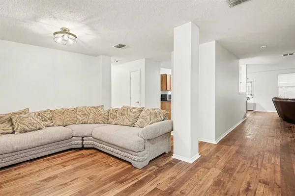 a living room with furniture and a wooden floor