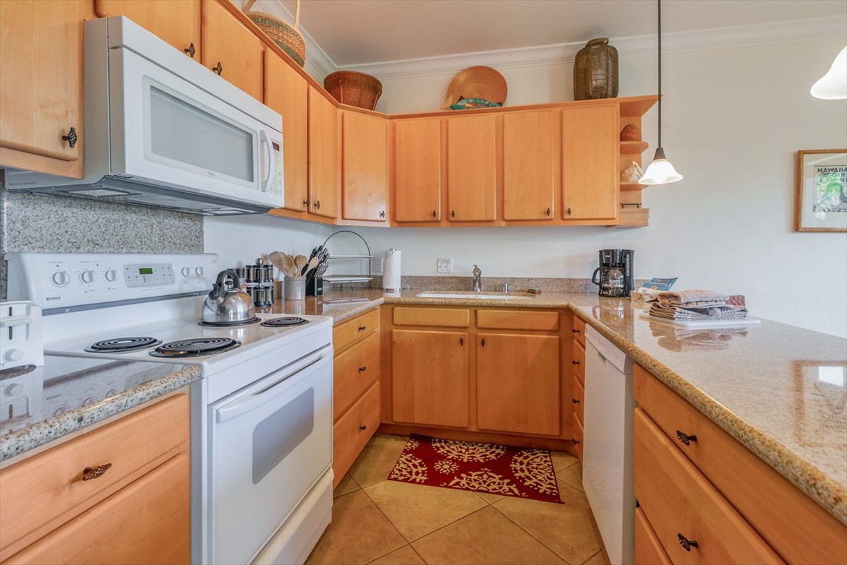 1901 Poipu Road, Unit 213 Koloa, HI 96756 - Photo 3 of 15 a kitchen with stainless steel appliances granite countertop a sink a stove and cabinets