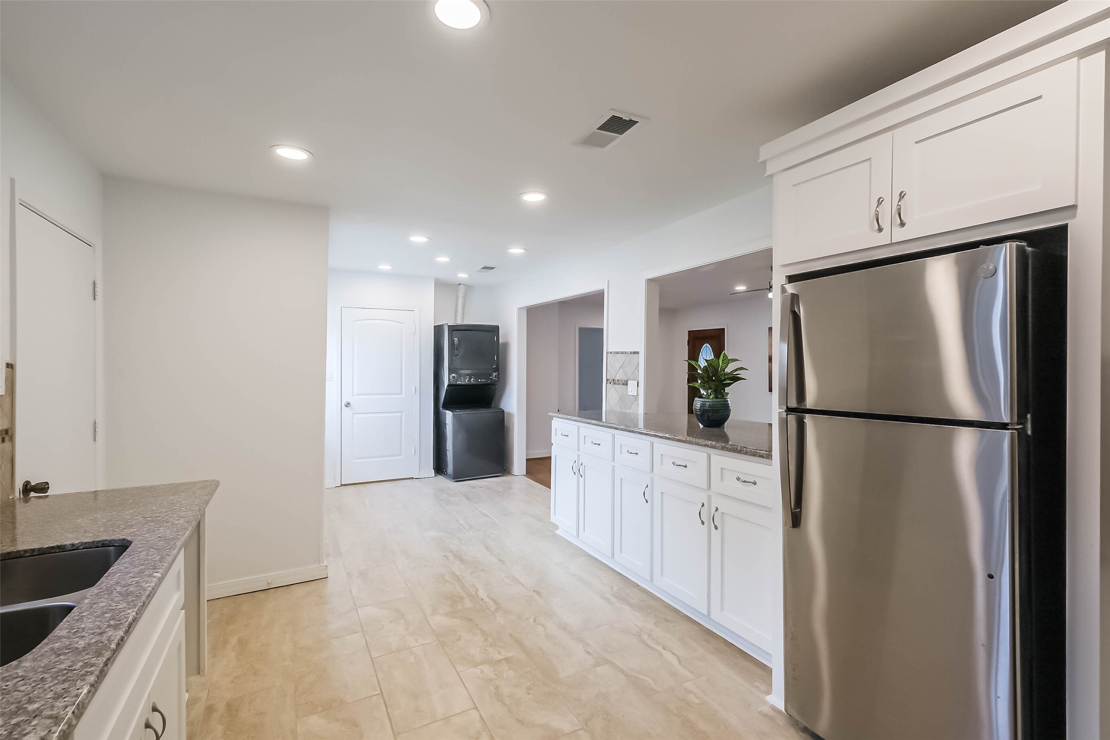 7543 Greenstone Street Houston, TX 77087 - Photo 7 of 24 a kitchen with refrigerator a sink and white cabinets