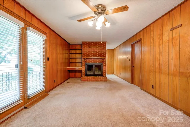 a view of an empty room with a fireplace and a window