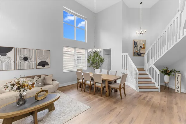 a view of a livingroom with furniture stairs wooden floor and windows