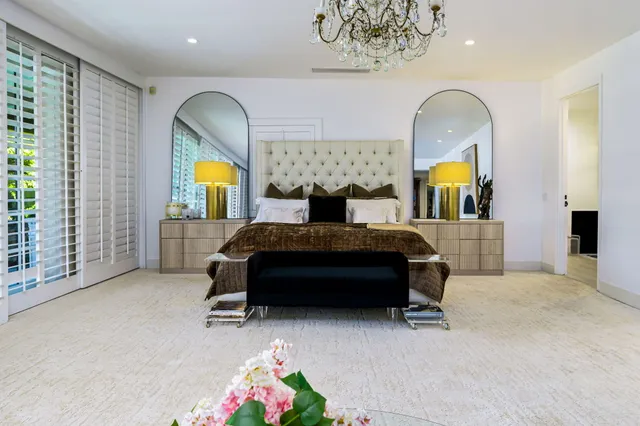 a bedroom with a bed a dresser and potted plants