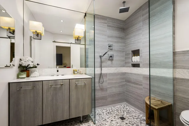 a bathroom with a sink vanity granite shower and a mirror