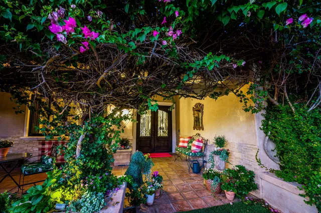 a front view of a house with a yard and fountain