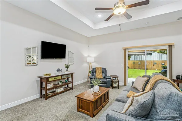 a living room with furniture a flat screen tv and a window