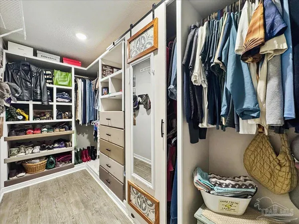a view of walk in closet with clothes and shoes