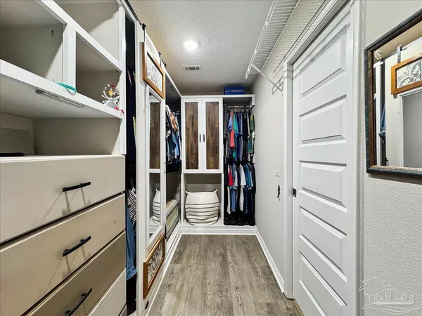 a view of walk in closet with clothes and shoes