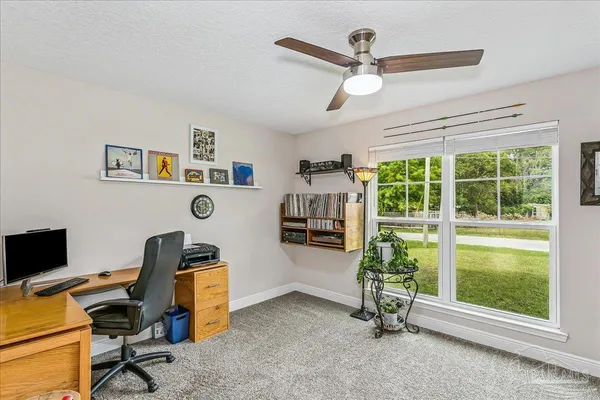 a view of a workspace with furniture and a window