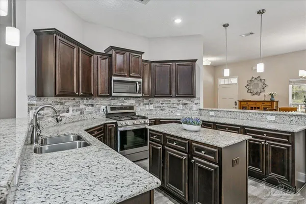 a kitchen with a stove sink and microwave